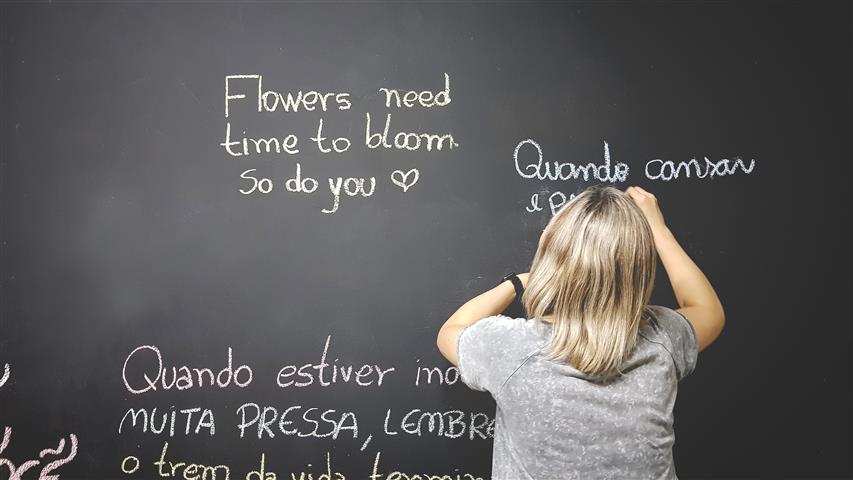 Kobieta pisze na tablicy szkolnej