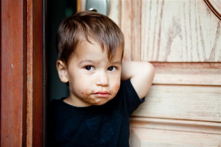 Kilkuletni chłopiec z buzią umorusaną czekoladą